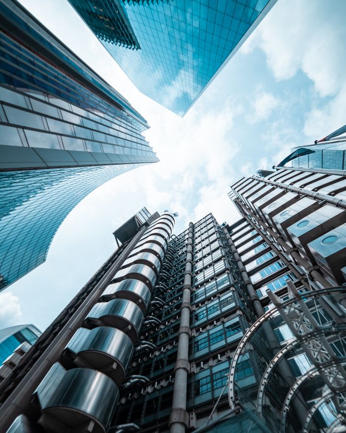Low angle view of modern skyscrapers in London, capturing sleek architectural designs against the sky.