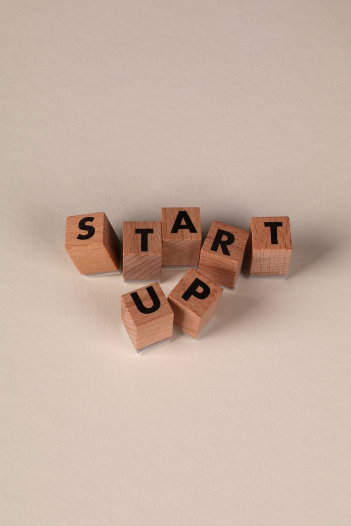 Wooden blocks spelling 'START UP' on a neutral background, symbolizing new beginnings.